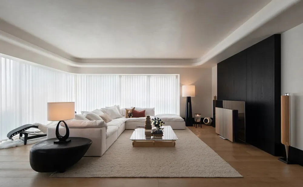 Original interior render of a modern living room: white sectional sofa, glass coffee table, black side table and a dark wood feature wall